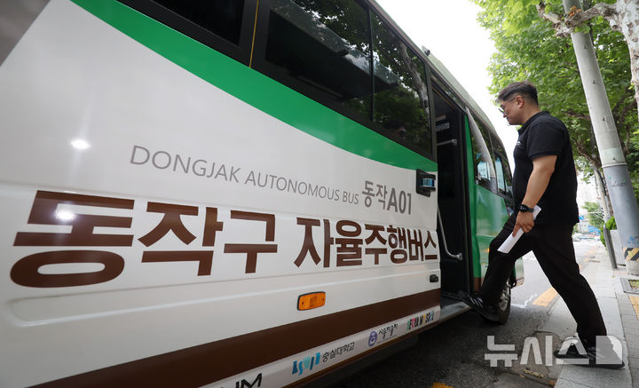 [서울=뉴시스] 조성우 기자 = '지역동행 자율주행버스'가 사전 운행을 시작한 30일 서울 동작구 숭실대학교 앞 정류장에서 관계자가 버스를 타고 있다. '지역동행 자율주행버스'는 자치구 단위 마을버스 성격으로 동작구에 최초로 도입되어 이날부터 2주간 사전 운행 후 오는 7월 14일부터 정식 운행한다.&nbsp; 2025.06.30. xconfind@newsis.com
