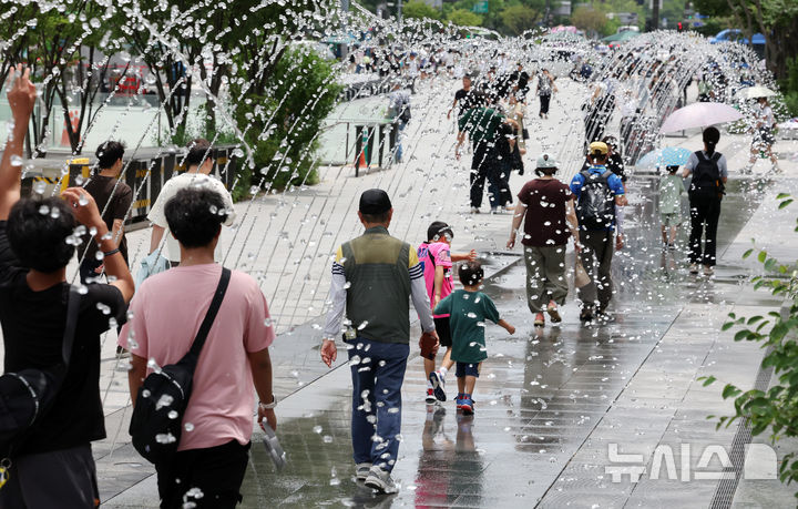[서울=뉴시스] 배훈식 기자 = 서울에 올해 첫 폭염주의보가 발효된 30일 오후 서울 종로구 광화문광장에서 관광객들이 바닥분수 터널을 걸으며 더위를 식히고 있다. 2025.06.30. dahora83@newsis.com