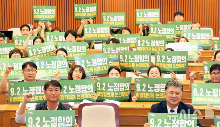 [서울=뉴시스] 김금보 기자 = 민주노총 전국보건의료산업노동조합 조합원들과 토론회 패널들이 30일 서울 여의도 국회박물관에서 열린 '이재명 정부 공약 및 정책협약 이행 과제 국회토론회, 보건의료 위기와 갈등의 시대! 이재명 정부 출범 100일 내 해결해야 할 최우선 과제는 무엇인가?'에서 직종별 인력기준 제도화와 9.2 노정합의 이행협의체 논의재개를 요구하는 피켓을 들고 구호를 외치고 있다. 2025.06.30. kgb@newsis.com