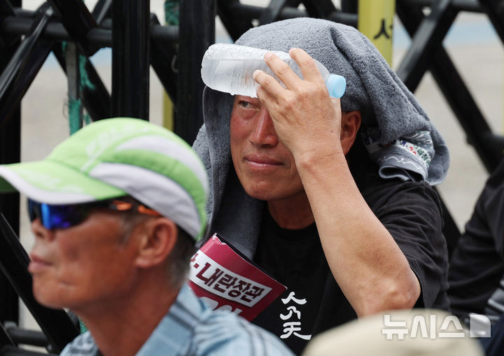 [서울=뉴시스] 김진아 기자 = 30일 서울 용산구 대통령실 인근에서 열린 국민과 함께하는 농민의길 주최 '송미령 농림축산식품부 장관 유임 철회, 내란농정 즉각 청산, 1차 전국농민결의대회'에서 한 참가자가 얼음물로 더위를 식히고 있다. 2025.06.30. bluesoda@newsis.com