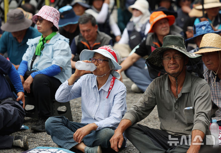 [서울=뉴시스] 김진아 기자 = 30일 서울 용산구 대통령실 인근에서 열린 국민과 함께하는 농민의길 주최 '송미령 농림축산식품부 장관 유임 철회, 내란농정 즉각 청산, 1차 전국농민결의대회'에서 한 참가자가 얼음물을 마시며 더위를 식히고 있다. 2025.06.30. bluesoda@newsis.com