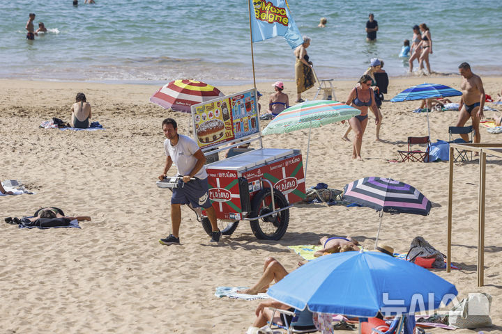 [생장드뤼즈=AP/뉴시스] 지난달 30일(현지 시간) 프랑스 남서부 생장드뤼즈 해변에서 한 노점상이 아이스크림을 팔고 있다. 프랑스 전역에서 40도를 웃도는 폭염이 기록된 가운데 프랑스 기상청은 이번 주 중반까지 일부 지역에서 40도를 넘는 고온 현상이 지속할 것으로 예보했다. 2025.07.01.