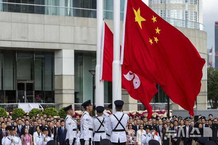 [홍콩=AP/뉴시스]지난달 1일(현지 시간) 홍콩에서 홍콩 반환 28주년 기념식이 열려 경찰 의장대가 중국 국기와 홍콩 특별행정구 깃발을 게양하고 있다. 홍콩은 1997년 7월 1일 영국으로부터 반환됐다. 2025.08.09.