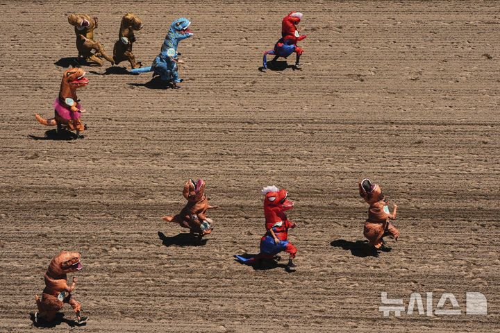 [오번=AP/뉴시스] 지난달 29일(현지 시간) 미국 워싱턴주 오번의 경마장 에메랄드 다운스에서 열린 '티렉스 세계 챔피언십 레이스'에서 참가자들이 결승선을 향해 달리고 있다. 2025.07.01.