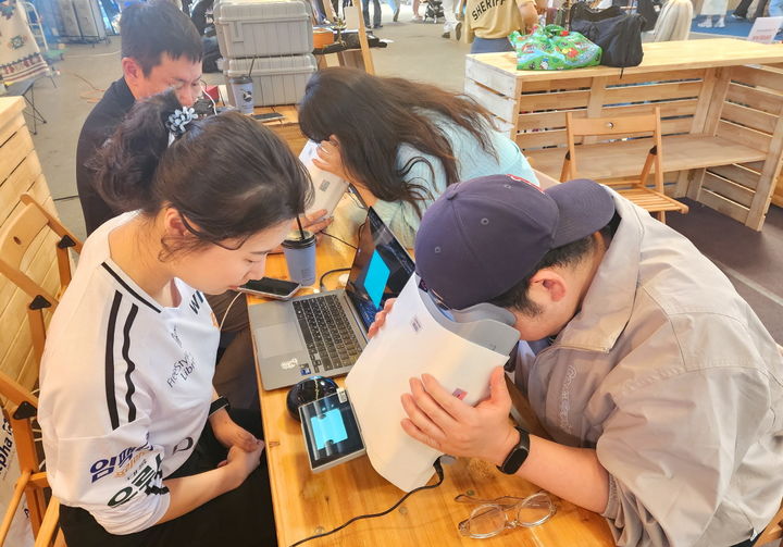 [서울=뉴시스] 대웅제약 부스 방문객이 위스키와 옵티나를 활용해 안저 상태를 확인하고 있다. (사진=대웅제약 제공) 2025.07.01. photo@newsis.com *재판매 및 DB 금지