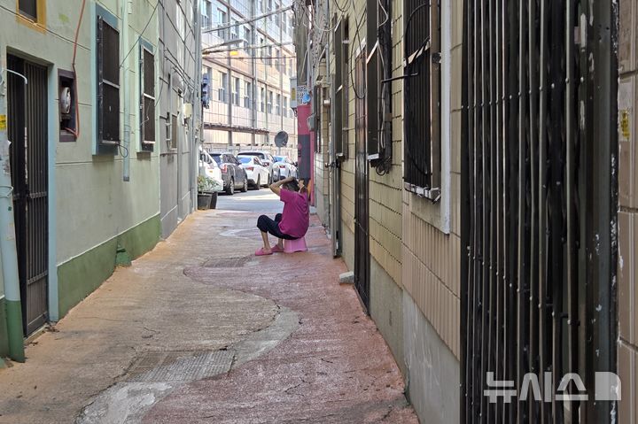 [부산=뉴시스] 김민지 기자 = 1일 오전 부산 부산진구 부암동 한 골목 단칸방에 홀로 살고 있는 장모(70대)씨는 집 안 갑갑한 공기를 피하고자 여름이면 대문 밖에 나와 앉아 있는다. 2025.07.01. mingya@newsis.com 