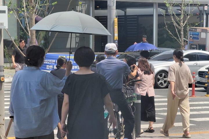 [대구=뉴시스] 이상제 기자 = 사흘째 폭염경보가 발효 중인 1일 대구 중구의 한 도로에서 시민들이 우산을 쓰고 걷고 있다. 2025.07.01. king@newsis.com *재판매 및 DB 금지