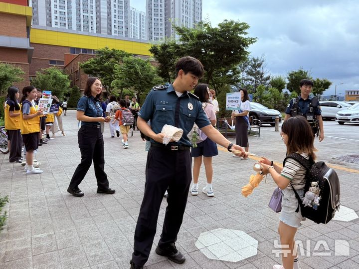 [시흥=뉴시스] 학교전담경찰관이 등교하는 학생에게 '학교 폭력 예방' 안내문을 전달하고 있다. (사진=시흥교육지원청).2025.07.01. photo@newsis.com