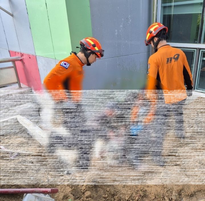 [계룡=뉴시스] 1일 오후 4시46분께 충남 계룡시 엄사면 유동리 계룡시민체육관 후문 공사장에서 돌 자르는 작업 중 기계에 베인 A씨 구조를 위해 현장에 출동한 구급대원들이 A씨 상태를 확인하고 있다. (사진=계룡소방서 제공) 2025.07.01. photo@newsis.com *재판매 및 DB 금지