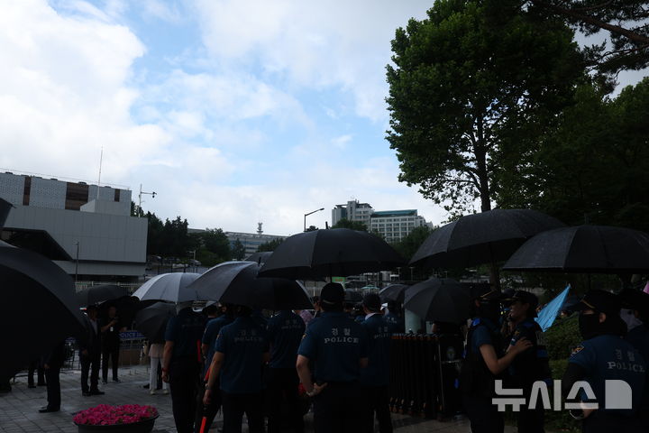 [서울=뉴시스] 조성우 기자 = 1일 서울 용산구 전쟁기념관 인근에서 내린 소나기에 경찰들이 우산을 쓰고 있다. 2025.07.01. xconfind@newsis.com