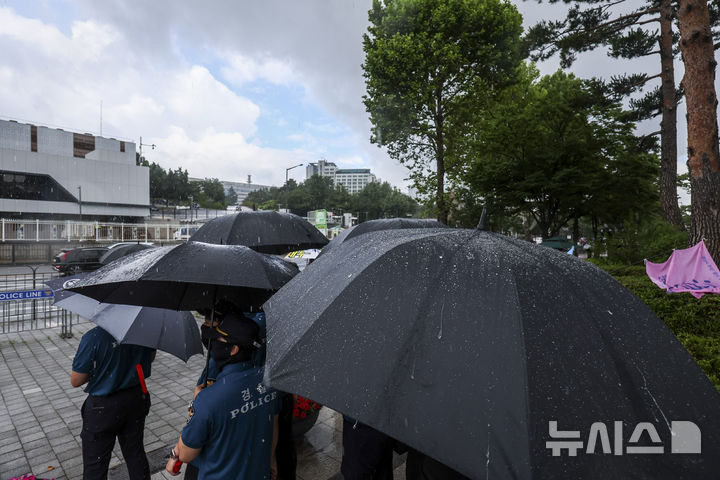 [서울=뉴시스] 조성우 기자 = 1일 서울 용산구 전쟁기념관 인근에서 내린 소나기에 경찰들이 우산을 쓰고 있다. 2025.07.01. xconfind@newsis.com