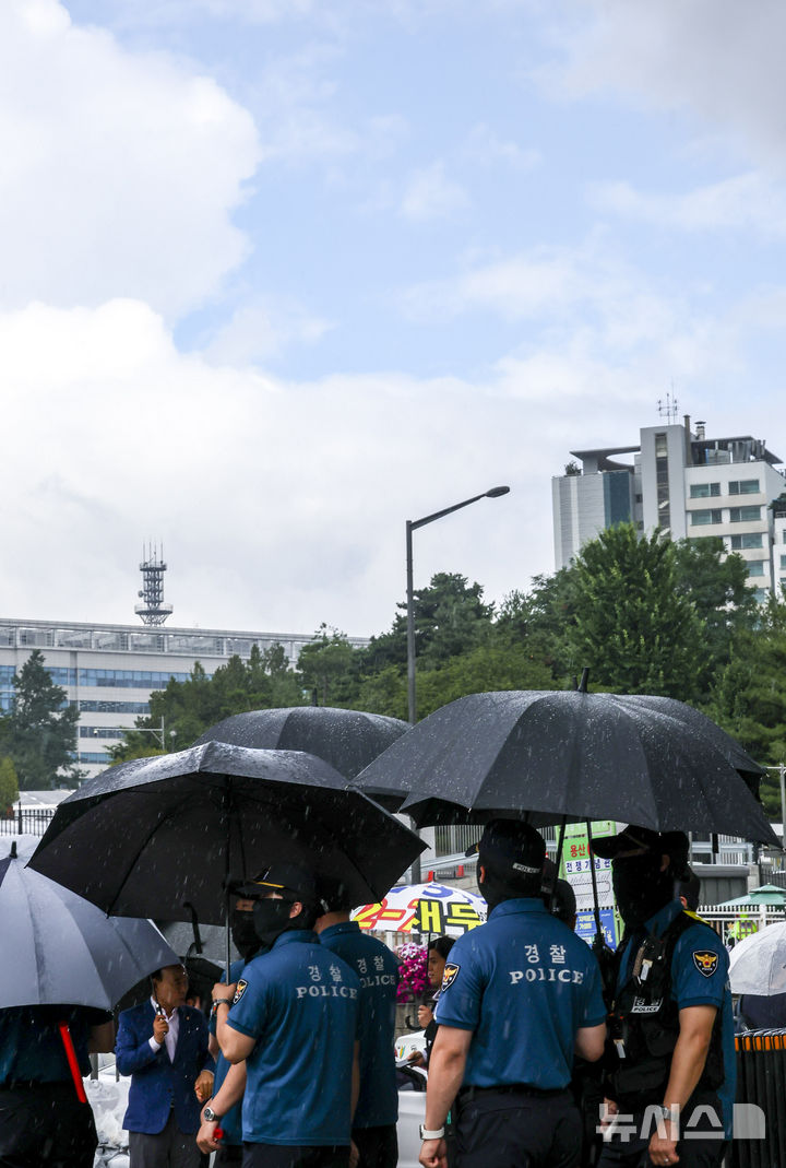 [서울=뉴시스] 조성우 기자 = 1일 서울 용산구 전쟁기념관 인근에서 내린 소나기에 경찰들이 우산을 쓰고 있다. 2025.07.01. xconfind@newsis.com