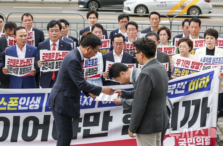 [서울=뉴시스] 조성우 기자 = 유상범 국민의힘 원내운영수석부대표가 1일 오전 서울 용산구 대통령실 앞에서 열린 현장 의원총회에서 대통령실 관계자에게 항의서한을 전달하고 있다. 2025.07.01. xconfind@newsis.com