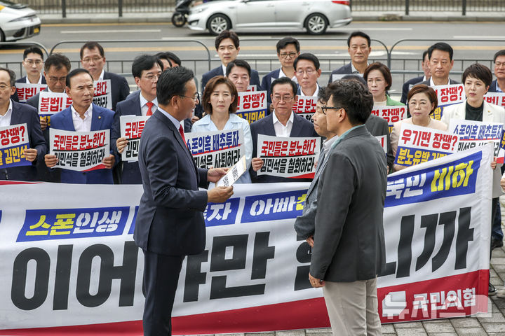 [서울=뉴시스] 조성우 기자 = 유상범 국민의힘 원내운영수석부대표가 1일 오전 서울 용산구 대통령실 앞에서 열린 현장 의원총회에서 대통령실 관계자에게 항의서한을 전달하고 있다. 2025.07.01. xconfind@newsis.com