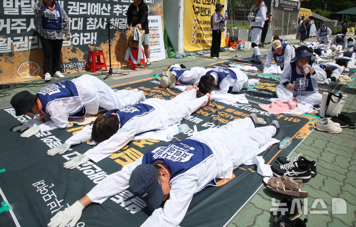 [서울=뉴시스] 김금보 기자 = 전국장애인부모연대 회원들이 7일 서울 여의도 국회 정문 앞에서 발달장애인 관련 예산과 권리 확대를 요구하며 오체투지를 하고 있다. 2025.07.01. kgb@newsis.com