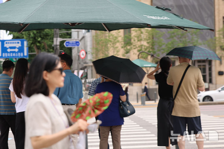 [서울=뉴시스] 권창회 기자 = 서울지역에 이틀째 폭염주의보가 지속 중인 지난 1일 서울 종로구 광화문광장 인근에서 시민들이 더위를 피해 그늘에서 신호대기를 하고 있다. 2025.07.01. kch0523@newsis.com