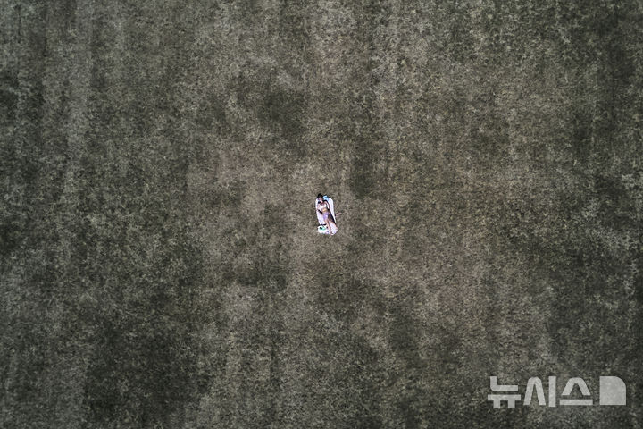 [프랑크푸르트=AP/뉴시스] 1일(현지 시간) 독일 프랑크푸르트 한 공원에서 한 여성이 무더운 날씨 속 메마른 풀밭에 누워 일광욕을 하고 있다. 2025.07.02.