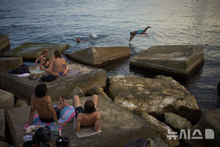 [바르셀로나=AP/뉴시스] 스페인에 무더위가 이어진 1일(현지 시간) 바르셀로나 해변을 찾은 시민들이 물놀이와 일광욕을 즐기고 있다. 2025.07.02.
