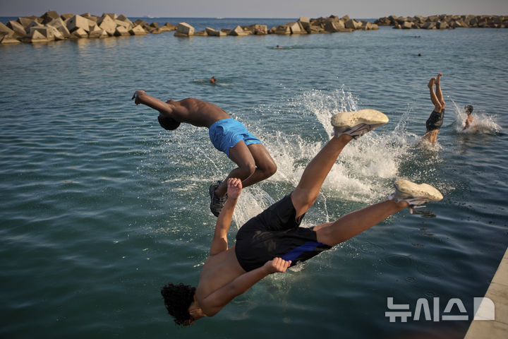 [바르셀로나=AP/뉴시스]스페인에 무더위가 이어진 1일 바르셀로나 해변에서 남성들이 물로 뛰어들고 있다. 지난달 말 서유럽을 강타한 파괴적 폭염으로 12개 주요 도시에서 약 2300명의 사망자를 낸 것으로 추정된다고 9일 발표된 과학적 분석 결과에서 나타났다고 아제르바이잔의 뉴스닷에이제트(news.az)가 보도했다. 2025.07.09.