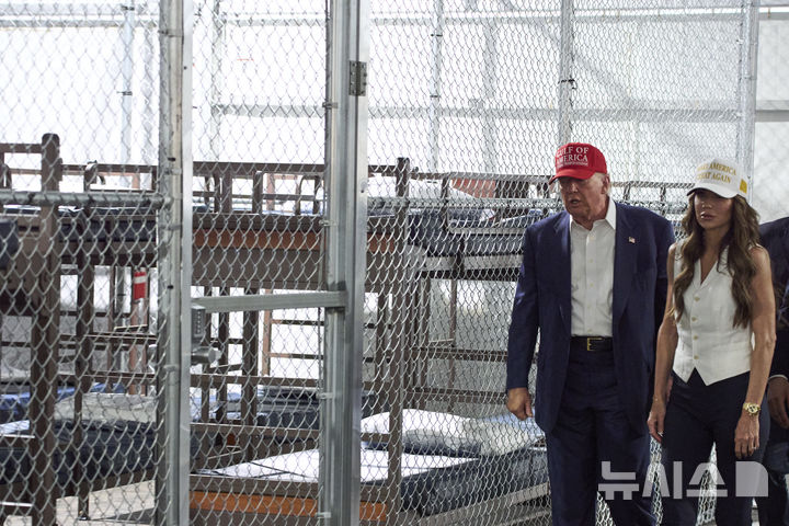 [오초피=AP/뉴시스] 도널드 트럼프(왼쪽) 미국 대통령이 1일(현지 시간) 크리스티 놈 국토안보부 장관과 함께 플로리다주 오초피에 있는 데이드-콜리어 훈련 및 전환 시설에 새로 들어선 이민자 구금시설 ‘앨리게이터 앨커트래즈’를 둘러보고 있다. 2025.07.02.