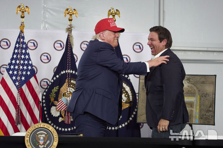 [오초피 ( 미 플로리다주)= AP/뉴시스]도널드 트럼프 미국 대통령이 올해 7월 1일 플로리다주 오초피에 세워진 새 이민수용소에서 론 디샌티스주지사의 노고를 칭찬하고 있다. 플로리다주에서는 사형수의 형집행이 늘어났는데 이런 일은 사형제도에 대한 국민의 찬반과 무관하게 대통령이나 주지사의 의지에 따라 집행속도가 좌우된다는 보고서도 나와있다. 2025. 07.16. 