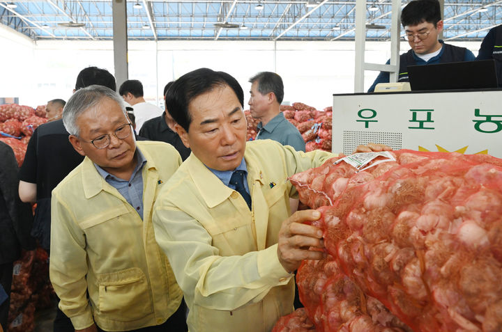 [창녕=뉴시스] 성낙인 군수가 2025년산 햇마늘 경매가 한창인 우포공판장을 방문해 현장을 점검하고 관계자들을 격려하고 있다. (사진= 창녕군 제공) 2025.07.02. photo@newsis.com *재판매 및 DB 금지