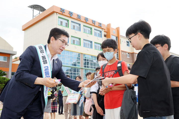 윤건영 충북도교육감(왼쪽)이 2일 청주 주중초등학교에서 교통안전 수칙과 물놀이 안전 행동 요령이 담긴 리플릿을 나눠주고 있다.(사진=충북교육청 제공).2025.07.02.photo@newsis.com *재판매 및 DB 금지