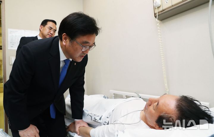 [서울=뉴시스] 우원식 당시 더불어민주당 원내대표가 10일 오후 '드루킹 특검'을 요구하며 8일째 단식농성 중 건강악화로 서울 여의도 한 병원 응급센테로 이송된 김성태 당시 자유한국당 원내대표를 방문해 대화를 나누고 있다. (사진=홍효식 기자) 2018.05.10.