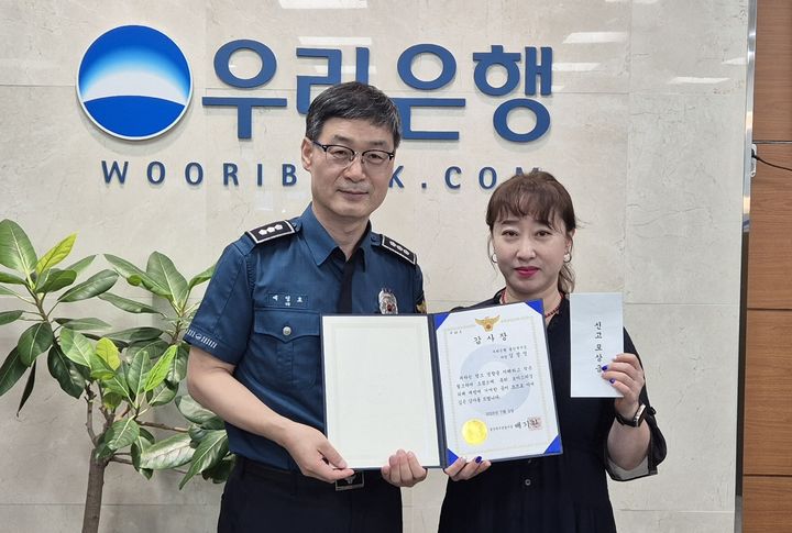 [울산=뉴시스] 박수지 기자 = 울산시 북부경찰서가 보이스피싱 범죄를 사전 차단해 현금 1000만원 피해를 막은 우리은행 울산북지점 김정영 차장에게 감사장과 112신고 포상금을 전달하고 있다. (사진=북부경찰서 제공) 2025.07.02. photo@newsis.com *재판매 및 DB 금지