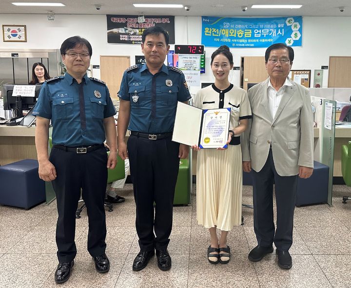 [서산=뉴시스] 황정인(왼쪽 2번째) 서산경찰서장이 지난 2일 서산농협 서부지점을 찾아 보이스피싱 사기를 막은 이 지점 직원 A(왼쪽 3번째)씨에게 감사장을 건넨 후 기념 사진을 찍고 있다. (사진=서산경찰서 제공) 2025.07.02. photo@newsis.com *재판매 및 DB 금지