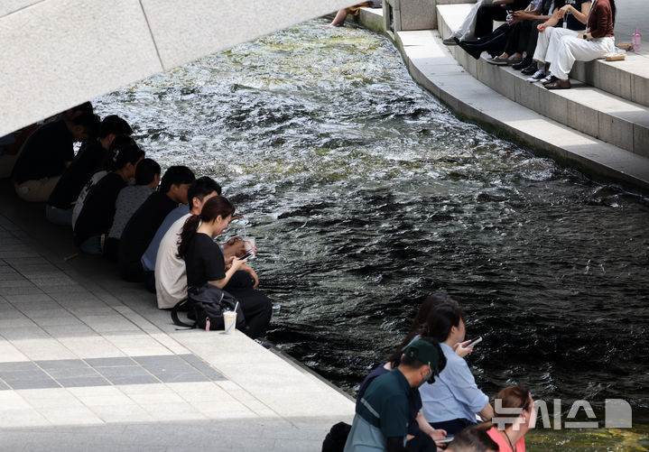 [서울=뉴시스] 배훈식 기자 = 전국 대부분 지역에 폭염특보가 발효된 2일 오후 서울 종로구 청계천을 찾은 시민들이 다리 아래 그늘에서 더위를 식히고 있다. 2025.07.02. dahora83@newsis.com