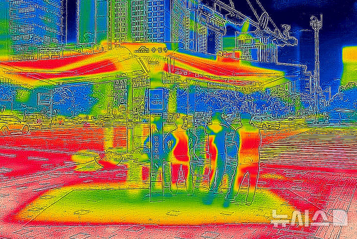 [대구=뉴시스] 이무열 기자 = 폭염이 연일 계속된 2일 대구 수성구 범어네거리에서 시민들이 그늘막 아래에 모여 횡단보도 신호를 기다리고 있다.&nbsp; 열화상카메라 화상은 온도가 높을수록 붉은색으로 나타나며 상대적으로 온도가 낮은 곳은 푸른색으로 나타난다. (열화상 카메라 촬영) 2025.07.02. lmy@newsis.com