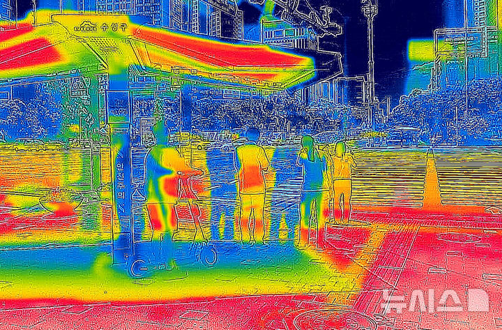 [대구=뉴시스] 이무열 기자 = 폭염이 연일 계속된 2일 대구 수성구 범어네거리에서 시민들이 그늘막 아래에 모여 횡단보도 신호를 기다리고 있다. 열화상카메라 화상은 온도가 높을수록 붉은색으로 나타나며 상대적으로 온도가 낮은 곳은 푸른색으로 나타난다. (열화상 카메라 촬영) 2025.07.02. lmy@newsis.com