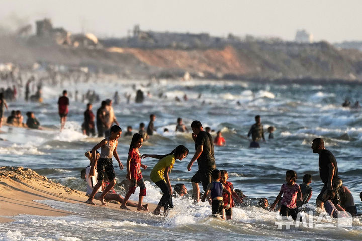 [가자시티=AP/뉴시스] 지난 2일(현지 시간) 가자시티 팔레스타인 피란민들이 지중해에서 물놀이를 하며 더위를 식히고 있다. 2025.07.08.