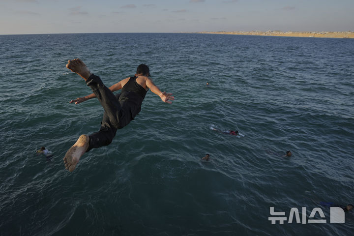A displaced Palestinian jumps into the water of the Mediterranean Sea to cool down during a heat wave in Khan Younis, Gaza Strip, Wednesday, July 2, 2025. (AP Photo/Abdel Kareem Hana)