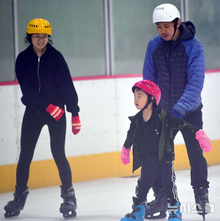 [광주=뉴시스] 이현행 기자 = 일주일째 폭염 특보가 이어지고 있는 3일 오후 광주 서구 염주체육관 실내빙상장에서 한 아이가 아빠의 부축을 받으며 스케이트를 타고 있다. 2025.07.03. lhh@newsis.com