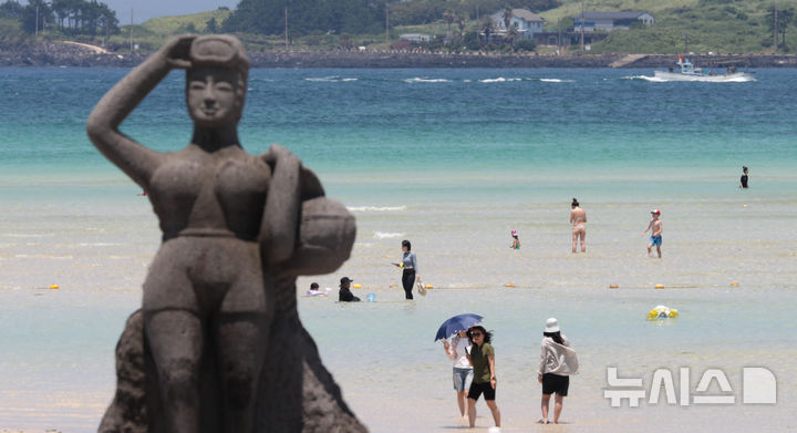 [제주=뉴시스] 우장호 기자 = 무더위가 기승을 부린 3일 오후 제주시 한림읍 금능해수욕장을 찾은 피서객들이 바닷물에 발을 담그며 더위를 식히고 있다. 2025.07.03. woo1223@newsis.com