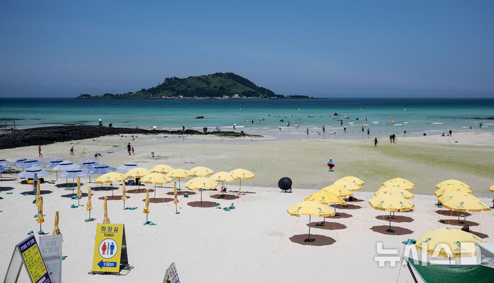 [제주=뉴시스] 우장호 기자 = 무더위가 기승을 부린 3일 오후 제주시 한림읍 협재해수욕장을 찾은 피서객들이 바닷물에 발을 담그며 더위를 식히고 있다. 기상청은 이날 제주 지역 장마가 사실상 지난달 26일 종료됐다고 발표했다. 올해 제주 장마 기간은 지난달 12~26일로 2주간이었으며, 이는 기상 관측 사상 가장 일찍 종료된 장마로 기록됐다. 2025.07.03. woo1223@newsis.com