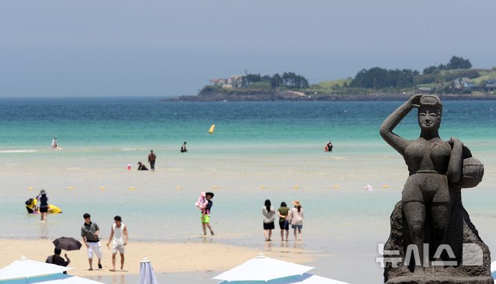 [제주=뉴시스] 우장호 기자 = 무더위가 기승을 부린 3일 오후 제주시 한림읍 금능해수욕장을 찾은 피서객들이 바닷물에 발을 담그며 더위를 식히고 있다. 기상청은 이날 제주 지역 장마가 사실상 지난달 26일 종료됐다고 발표했다. 올해 제주 장마 기간은 지난달 12~26일로 2주간이었으며, 이는 기상 관측 사상 가장 일찍 종료된 장마로 기록됐다. 2025.07.03. woo1223@newsis.com