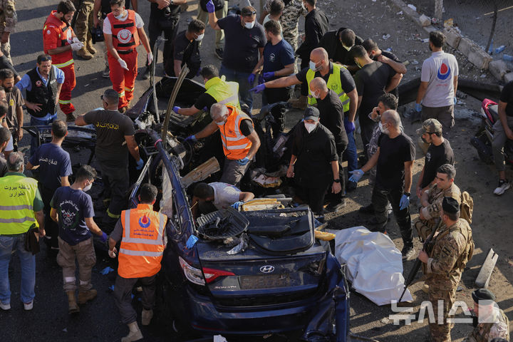 [할데=AP/뉴시스] 3일(현지 시간) 레바논 베이루트 남부 할데에서 민방위대원들이 이스라엘 드론 공습으로 파괴된 자동차에 있는 희생자 시신을 수습하고 있다. 2025.07.04