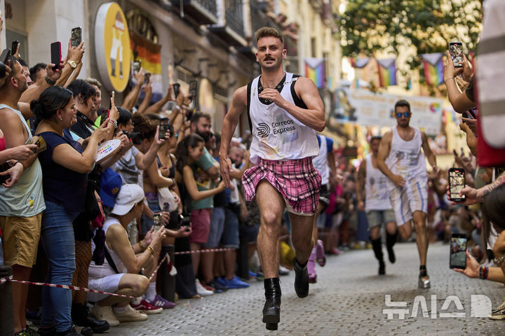 [마드리드=AP/뉴시스] 3일(현지 시간) 스페인 마드리드에서 열린 '마드리드 프라이드 주간의 연례 하이힐 레이스'에 참가한 참가자들이 높이 15cm의 하이힐을 신고 달리고 있다. 2025.07.04.