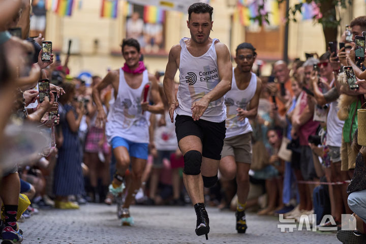 [마드리드=AP/뉴시스] 3일(현지 시간) 스페인 마드리드에서 열린 '마드리드 프라이드 주간의 연례 하이힐 레이스'에 참가한 참가자들이 높이 15cm의 하이힐을 신고 달리고 있다. 2025.07.04.