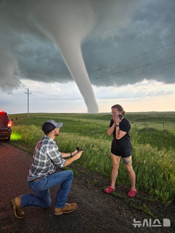 [뉴시스] 거대한 토네이도 앞에서 프러포즈한 커플의 사진이 SNS에서 1700만 뷰를 돌파하며 화제를 모았다. (사진=X) 2025.06.29