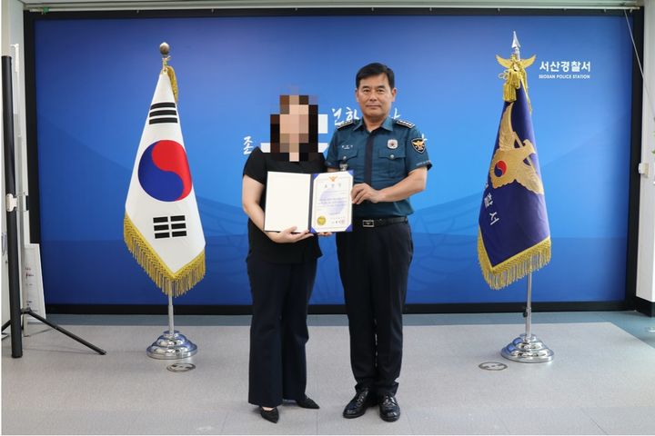 [서산=뉴시스] 황정인(오른쪽) 서산경찰서장이 4일 본서에서 수차례 신고 전화로 범죄 예방에 기여한 A씨에게 표창장을 건넨 후 기념 사진을 찍고 있다. (사진=서산경찰서 제공) 2025.07.04. photo@newsis.com  *재판매 및 DB 금지