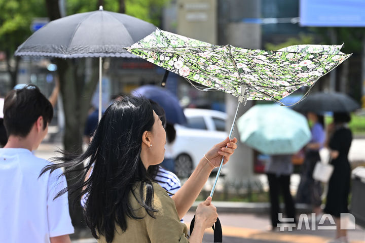 [광주=뉴시스] 이영주 기자 = 광주지역에 폭염특보가 8일째 이어지고 있는 4일 오후 광주 북구청 사거리에서 한 시민이 양산을 펼치고 있다. 2025.07.04. leeyj2578@newsis.com