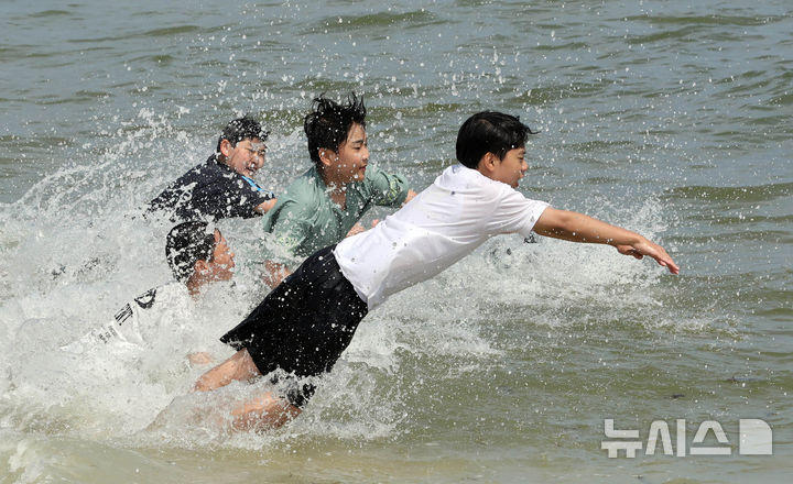  [부산=뉴시스] 하경민 기자 = 부산에 폭염경보가 발효 중인 4일 해운대해수욕장을 찾은 학생들이 시원한 바다에 뛰어들고 있다. 2025.07.04. yulnetphoto@newsis.com