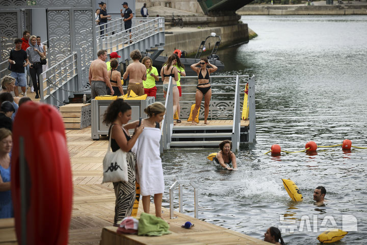 [파리=AP/뉴시스] 5일(현지 시간) 프랑스 파리 센 강에서 시민들이 수영을 하고 있다. 센 강은 100여 년 만에 공공 수영 공간으로 개방됐다. 마리 수로, 베르시 강변, 그르넬 항구 근처 등 세 곳이 야외 수영 구역으로 지정됐으며 오는 8월 31일까지 무료로 개방된다. 탈의실, 샤워 시설, 파라솔, 비치체어 등이 갖춰졌다. 2025.07.07.