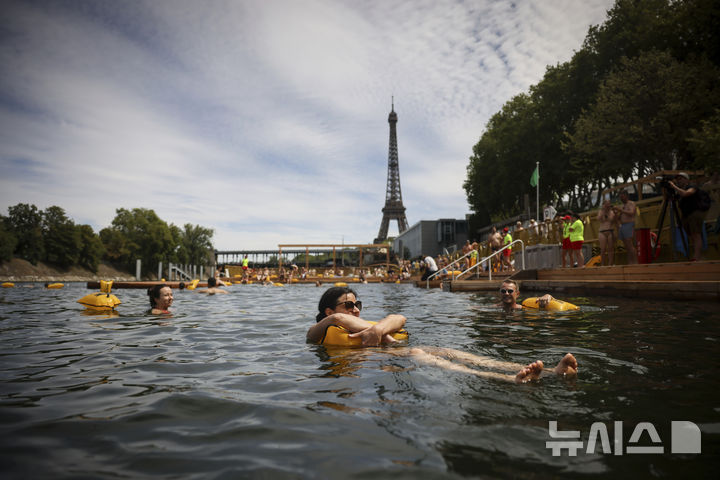 [파리=AP/뉴시스] 5일(현지 시간) 프랑스 파리 센 강에서 시민들이 수영을 하고 있다. 센 강은 100여 년 만에 공공 수영 공간으로 개방됐다. 마리 수로, 베르시 강변, 그르넬 항구 근처 등 세 곳이 야외 수영 구역으로 지정됐으며 오는 8월 31일까지 무료로 개방된다. 탈의실, 샤워 시설, 파라솔, 비치체어 등이 갖춰졌다. 2025.07.07.