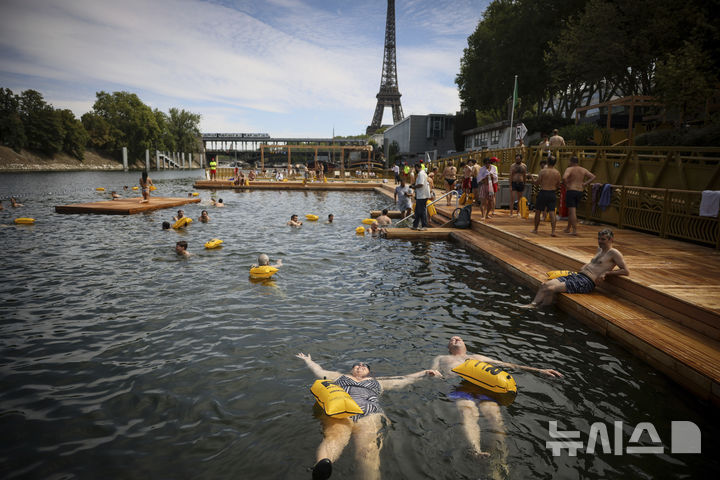 [파리=AP/뉴시스] 5일(현지 시간) 프랑스 파리 센 강에서 시민들이 수영을 하고 있다. 센 강은 100여 년 만에 공공 수영 공간으로 개방됐다. 마리 수로, 베르시 강변, 그르넬 항구 근처 등 세 곳이 야외 수영 구역으로 지정됐으며 오는 8월 31일까지 무료로 개방된다. 탈의실, 샤워 시설, 파라솔, 비치체어 등이 갖춰졌다. 2025.07.07.