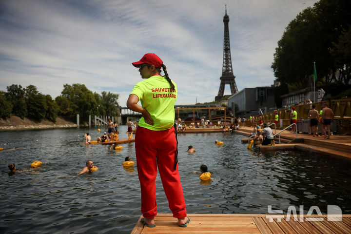 <font style="vertical-align: inherit;"><font style="vertical-align: inherit;">[파리=AP/뉴시스] 5일(현지 시간) 프랑스 파리 센 강에서 시민들이 수영을 하고 있는 가운데 안전요원이 배치돼 있다. 센 강은 100여 년 만에 공공 수영 공간으로 개방됐다. 마리 수로, 베르시 강변, 그르넬 항구 근처 등 세 곳이 야외 수영 구역으로 지정됐으며 오는 8월 31일까지 무료로 개방된다. 탈의실, 샤워 시설, 파라솔, 비치체어 등이 갖춰졌다. 2025.07.07.</font></font>